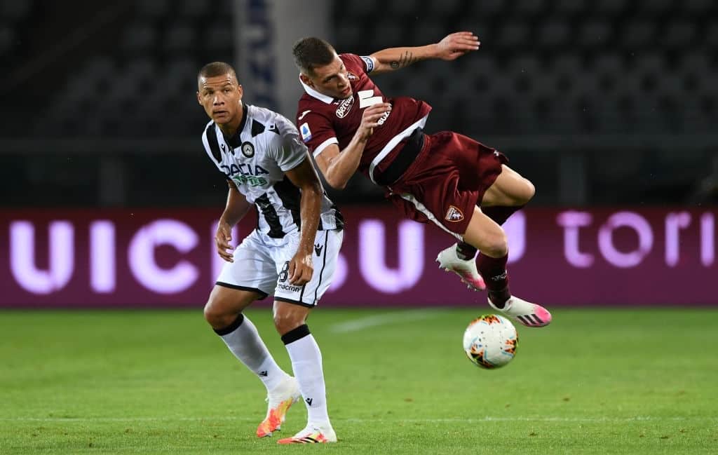TURIN, ITALY - JUNE 23: Sebastien De Maio of Udinese challenged by Andrea Belotti of Torino FC during the Serie A match between Torino FC and Udinese Calcio at Stadio Olimpico di Torino on June 23, 2020 in Turin, Italy. (Photo by Chris Ricco/Getty Images)